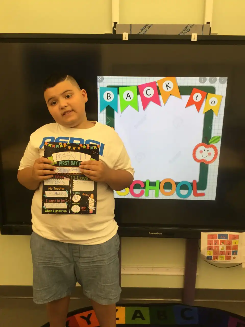 boy holding an all about me card with his name and other personal facts.