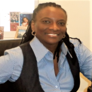 Principal Debbie Edmonds in her office wearing a blue striped shirt and black vest