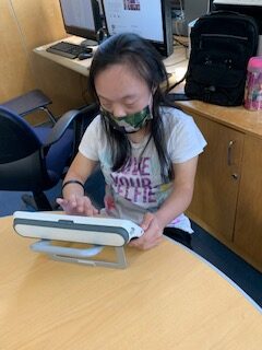 female student using a communication device to communicate.