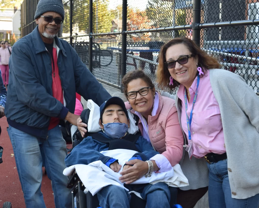 Student in a wheel chair and his teachers walking for breast cancer research.