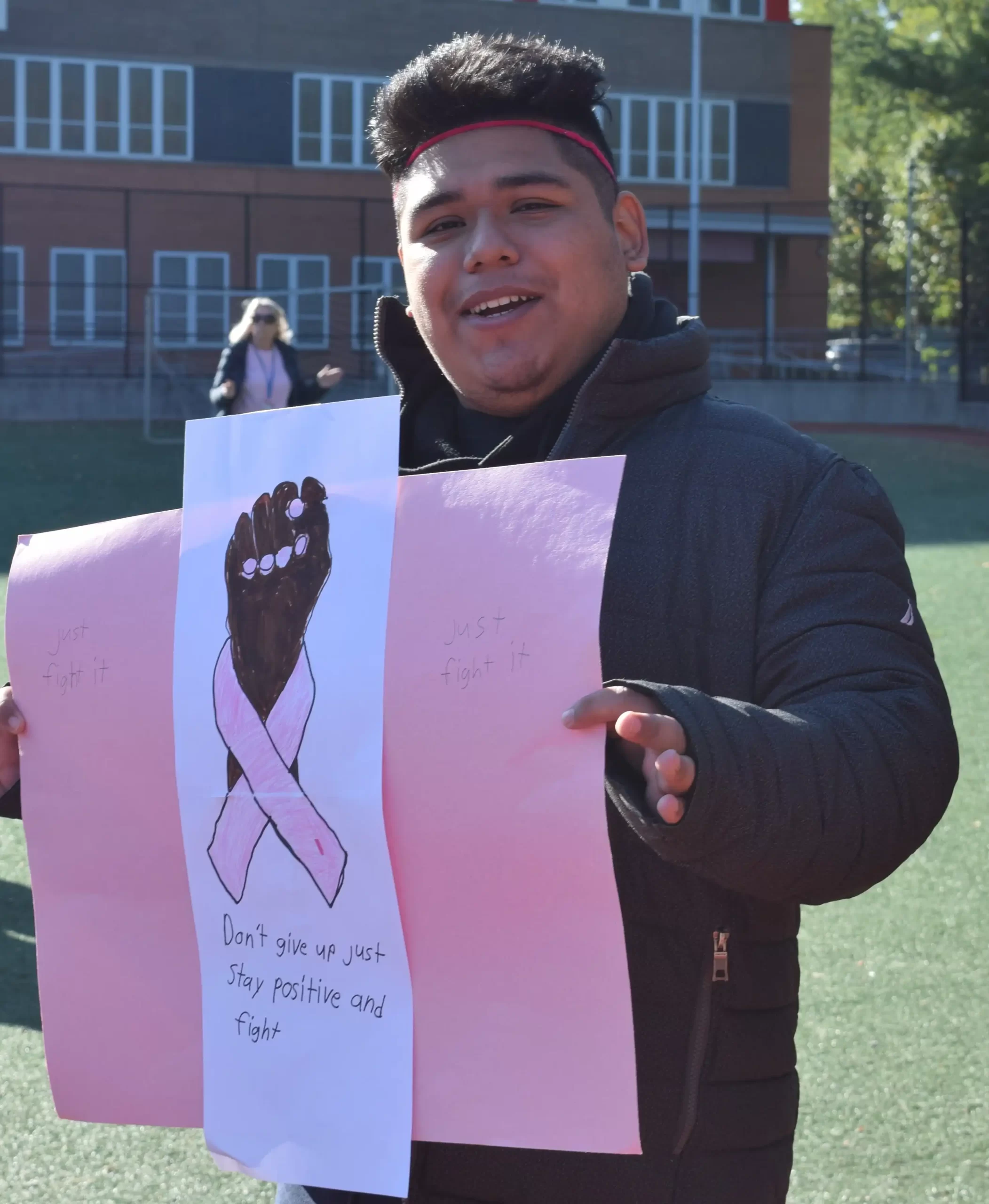 Luis with the poster he made for Breast Cancer Awareness