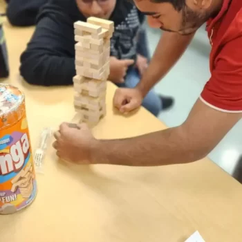 Two male students playing a black game called Jenga in the cafeteria