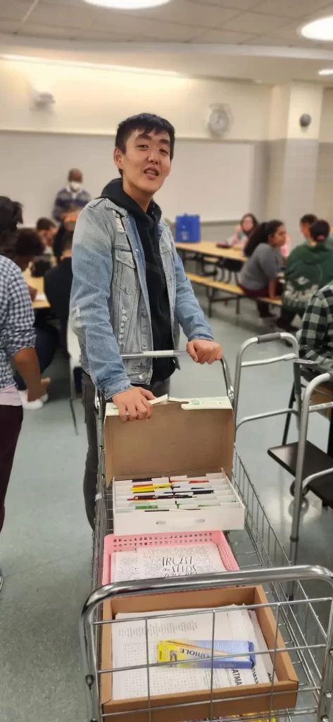 Male student pushing a cart with supplies