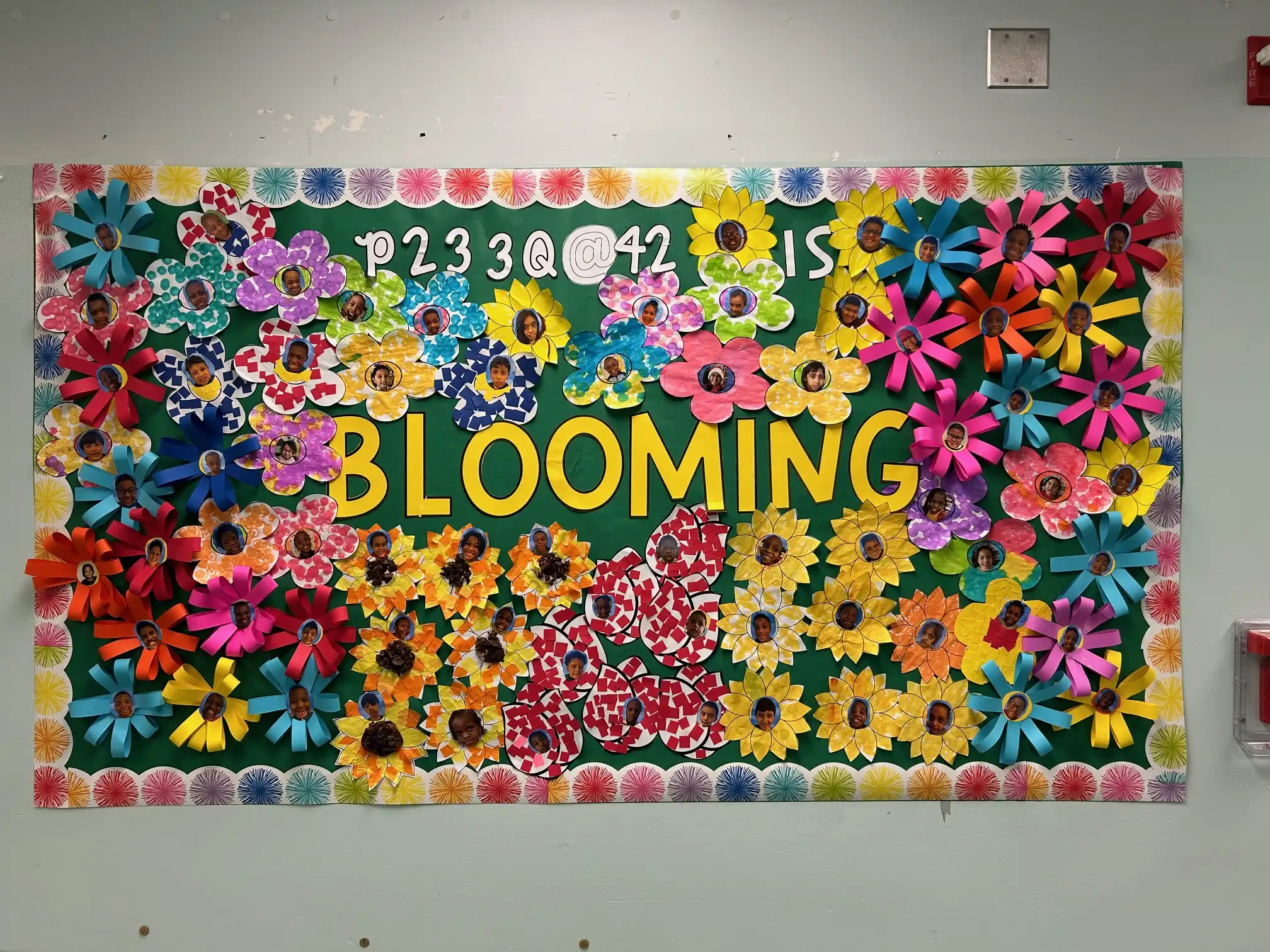 Bulletin board full of paper flowers of different colors