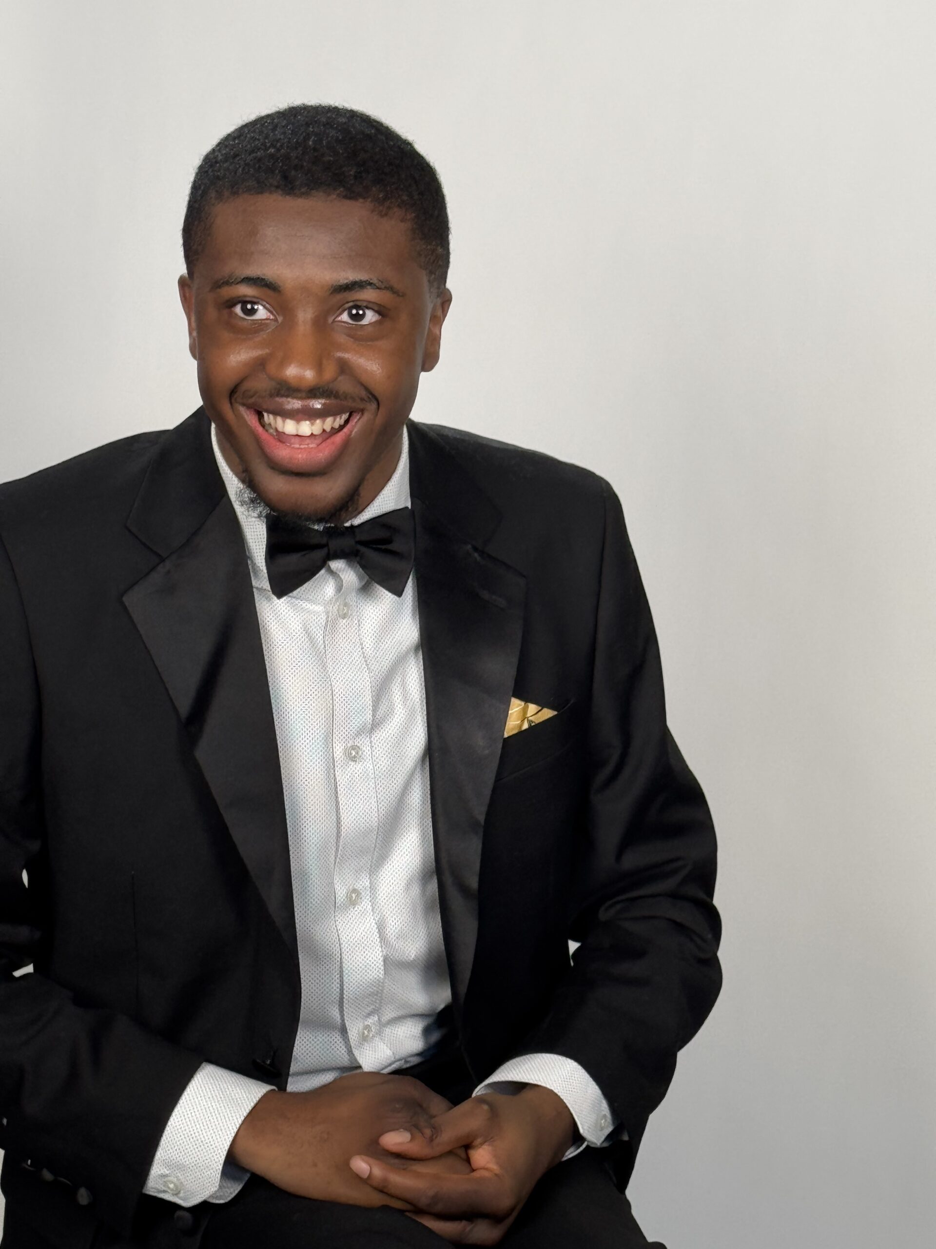 student smiling in tuxedo