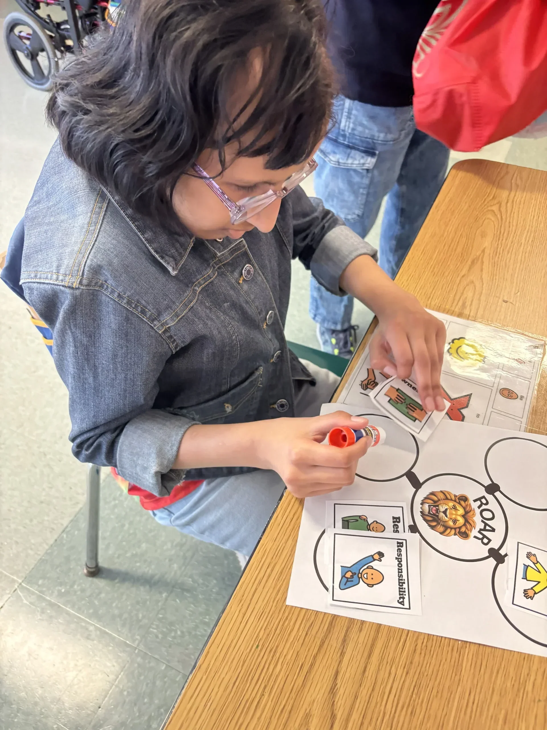 Student using glue stick to answer a worksheet
