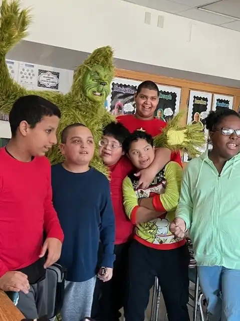 The grinch and six male students in a classroom